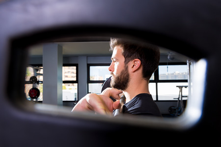 Barbell man weightlifting workout view through a weight bell hole