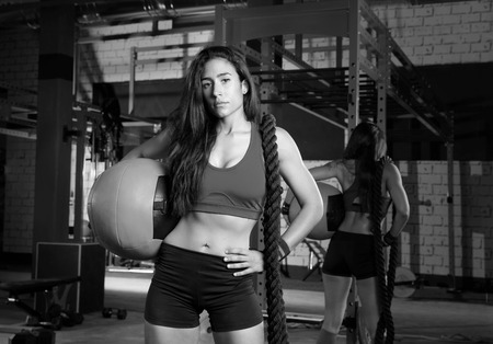Brunette gym woman with weighted ball and rope posingの写真素材