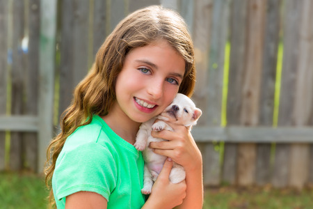 kid girl with puppy pet chihuahua playing happy with doggy outdoorの写真素材