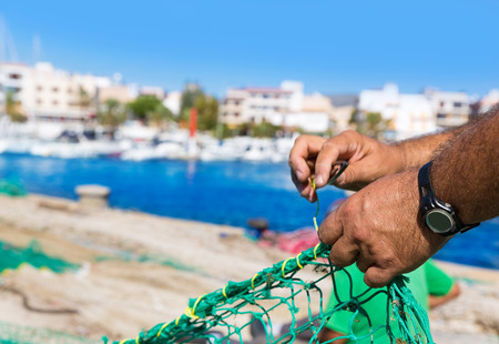 Majorca Cala Ratjada beach Rajada fisherman sewing fishing net