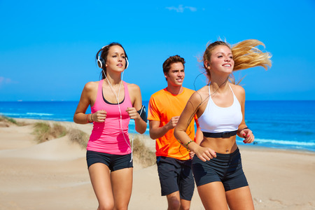friends running on the beach happy in summer sunny day