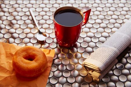 Coffee red cup newspaper and dona morning breakfast on vintage wooden tableの写真素材