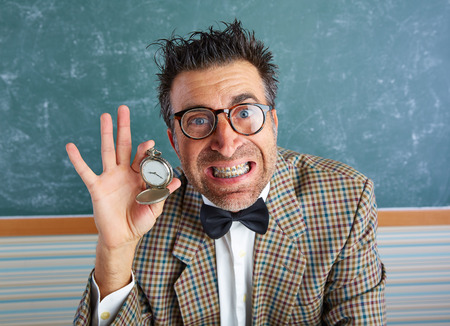 Nerd silly teacher showing vintage chain watch in green blackboard