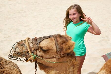 Girls riding Camel in Fuerteventura desert at Canary Islands of Spainの写真素材