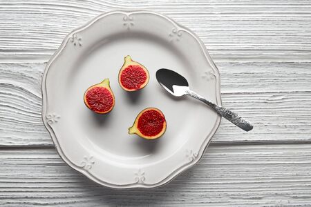 figs raw cutted fig fruits on white plate and wooden table