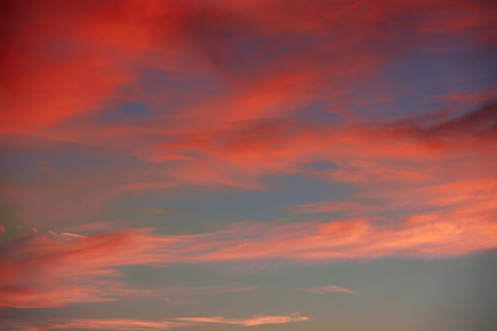 Red orange clouds in dramatic sunset blue sky