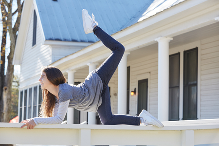 Tween kid girl training gymnastics on the park house fenceの写真素材