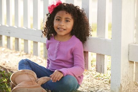 Happy toddler kid girl portrait in a park fence latin ethnicityの写真素材