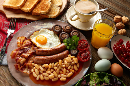 English breakfast with sausages egg beans bacon mushrooms and grilled tomato