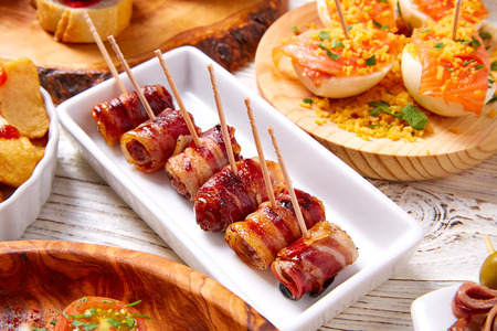 Tapas mix and pinchos food from Spain recipes also pintxos on a white wood boardの写真素材