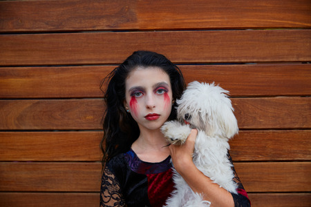 Halloween kid girl custome with bloody makeup on wooden wallの写真素材