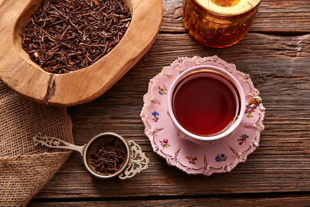kukicha tea served pink vintage cup on wooden table boardの写真素材