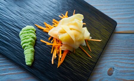 Ginger and Wasabi on a carrots bed and black slate boardの写真素材