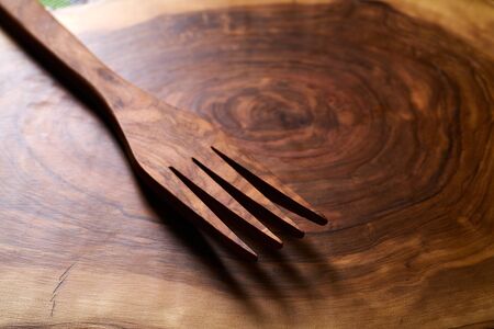 Olive wood fork on same wooden cutting boardの写真素材