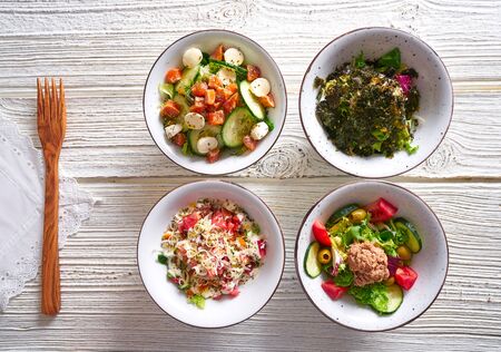 four salad mix bowls healthy food on white wood tableの写真素材