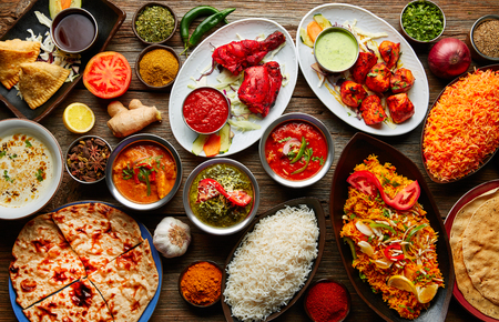 Assorted Indian recipes food various with spices and rice on wooden table Assorted Indian recipes food various with spices and rice on wooden table