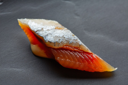 Bota sardine macro slice closeup on black slate dish