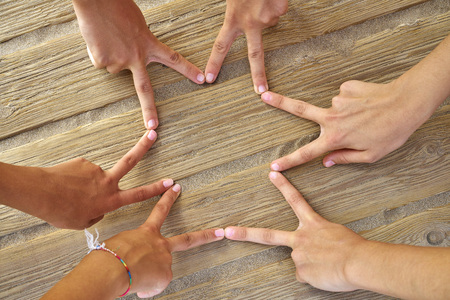 Star shape with six hand fingers on a beach woodの写真素材