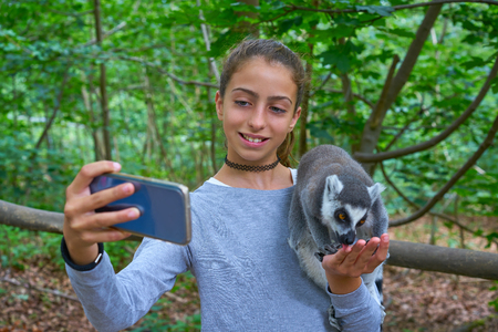 Kid girl having fun with ring tailed lemurs selfie photo animals outdoor