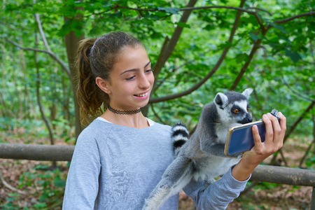 Kid girl having fun with ring tailed lemurs selfie photo animals outdoor