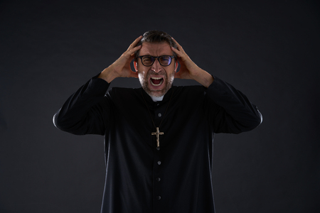 Mad crazy priest fear expression scaredの写真素材