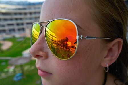 Girl profile with tropical palm trees reflected in the sunglassesの写真素材