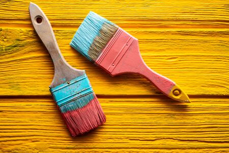 Coral color and yellow vivid grunge brushes on aged painted woodの写真素材