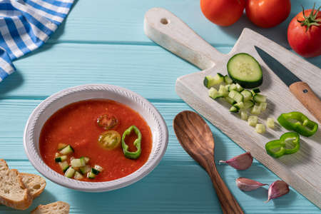 Gazpacho Andaluz is an Andalusian tomato cold soup from Spain with cucumber, garlic, pepper on light blue backgroundの写真素材
