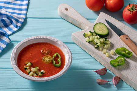 Gazpacho Andaluz is an Andalusian tomato cold soup from Spain with cucumber, garlic, pepper on light blue backgroundの写真素材