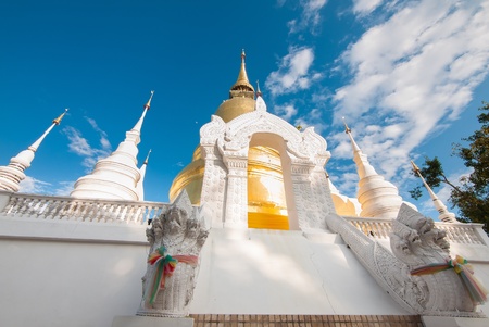 The golden pagoda in Wat Suan Dok, Chiangmai, Thailand contrasted with beutiful blue sky and clouds の写真素材