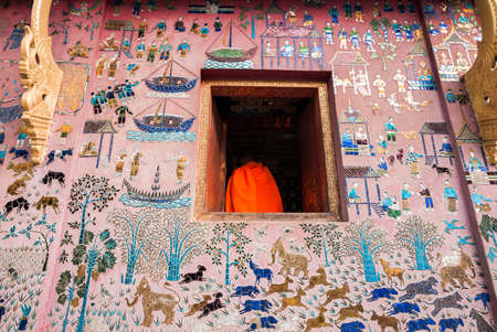 A picture through a temple window of Laos novice monk の写真素材