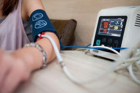 Measuring female blood pressure in a hospitalの写真素材