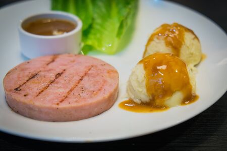 Ham steak served with potatoの写真素材