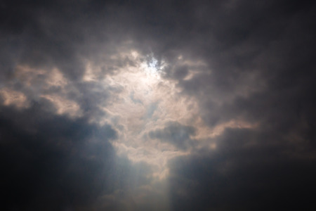 Light rays shine through dark clouds