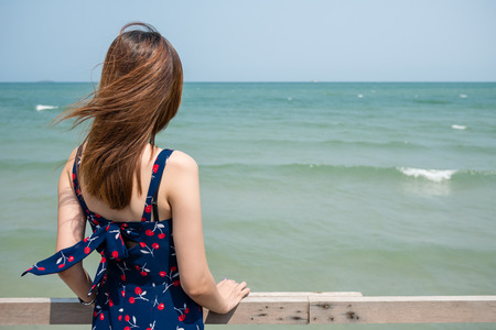 Back of a girl looking into the seaの写真素材