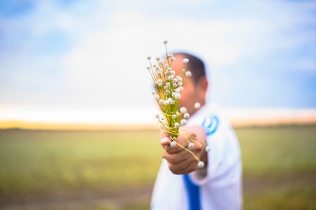 Blur people is holding beautiful bouquet of autumn grass flowers in his hand. The guy decided to make a surprise to his girlfriend. Romantic gift for the girl. Nature forest in autumn. background blurの写真素材