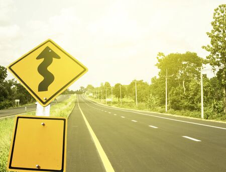 Warning road sign with sunlight.