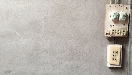 Close up of Light Switch with copy space to the side on cement wall background. In the house which is dangerous There may be an electric shock.Safety concept in life and property.の写真素材