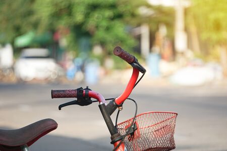 Close up old red bike for children. child on a bicycle at asphalt road in park. Defocused and blurred image for background of bike, activities at public park.の写真素材