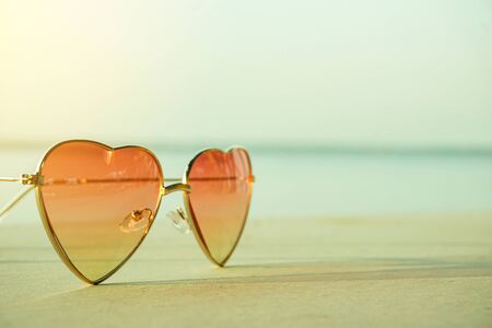 Close-up of sunglasses ,Beautiful heart shaped fashion glasses placed on the beach floor and blurred...