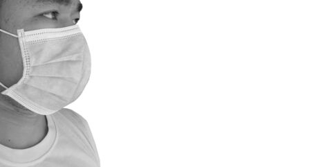 Blurred closeup image Black and white Portrait of man in a surgical face mask on a background , coronavirus, illness, infection, quarantine, medical mask concept.の写真素材