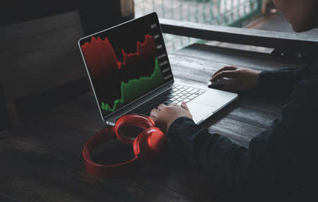 Close Up hand using laptop computer and looking for financial information in business, working on tablet with graphs,diagrams on monitor. Crypto currencies work from home concept.の写真素材