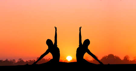 Yoga  silhouettes  isolated on sunset backgroundの写真素材