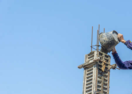 Construction under the building with mason plastering concrete to a cement floor.の写真素材