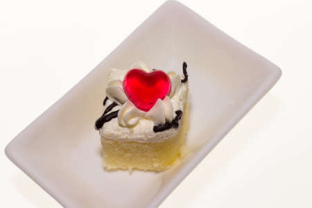 Red heart shaped cake on a plate.on white backgroundの写真素材