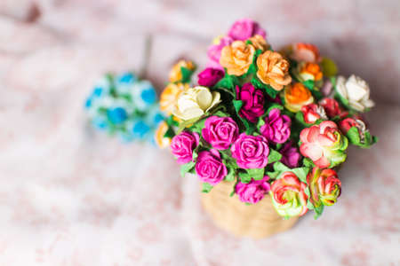 beautiful bouquet of bright wildflowers in basket on pink pattern backgroundの写真素材