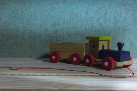 still life photography children toy train made of wood on wall and wood backgroundの写真素材