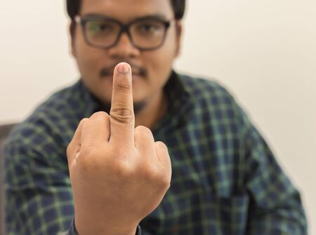 Man wearing glasses showing the middle fingerの写真素材