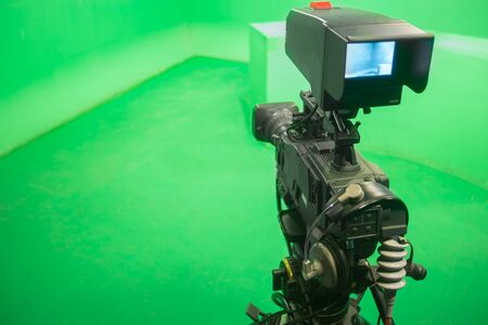 Television studio with camera and lights - camera on green screen