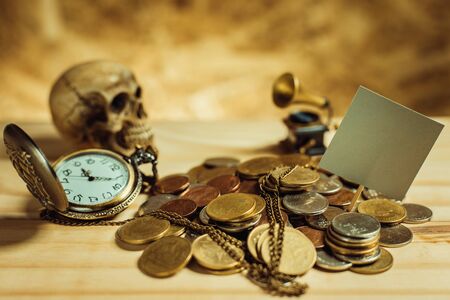 Focus in label Gray.Pile of money, Thai coins of one bath on wood element antique clock,skull,vintage gramophone background.Concept of financial planning and savings.Vintage tone.の写真素材